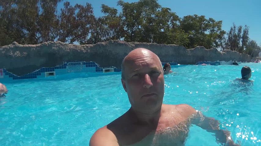 Bald man diving underwater swimming pool and blowing air bubble ...